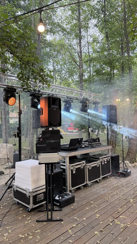 Pupitrul DJ cu boxe, lumini și mașină de fum, montat în aer liber